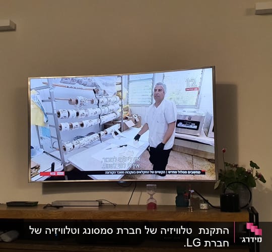 אדם עם כפפות ליד גלילי נייר במפעל